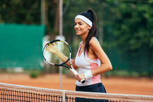 Smiling Sportswoman With Racket At Tennis Court