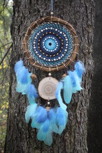 A Beautiful Blue Dream Catcher With Feathers.