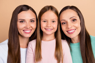 Canvas Print - Portrait of three attractive cheerful cute affectionate girls bonding isolated over beige pastel color background