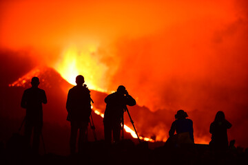 Human silhouettes recording, photographing and observing the exploding lava in La Palma Canary Islands 2021