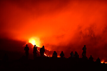 Human silhouettes recording, photographing and observing the exploding lava in La Palma Canary Islands 2021