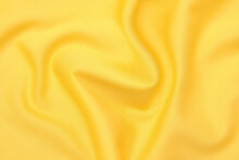Close-up Texture Of Natural Orange Or Yellow Fabric Or Cloth In Same Color. Fabric Texture Of Natural Cotton, Silk Or Wool, Or Linen Textile Material. Yellow Canvas Background.