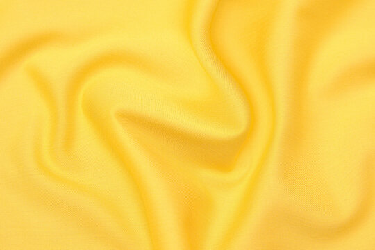 Wall Mural -  - Close-up texture of natural orange or yellow fabric or cloth in same color. Fabric texture of natural cotton, silk or wool, or linen textile material. Yellow canvas background.
