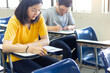 © panitan - high school,university student study.hands holding pencil writing paper answer sheet.sitting lecture chair taking final exam attending in examination classroom.concept scholarship for education abroad