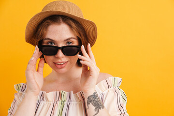 Wall Mural - Young ginger woman in sunglasses looking at camera