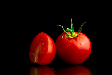 Wall Mural - Washed cherry tomatoes on a black background. Close-up view. Healthy eating concept photo