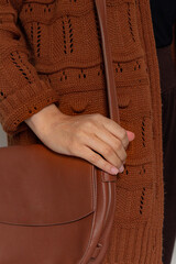 Young pretty woman in brown sweater with on white background. Fall, autumn fashion composition.