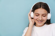 © Drobot Dean - Young woman smiling while listening music with headphones