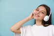 © Drobot Dean - Young woman smiling while listening music with headphones