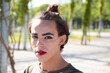 young latina transsexual woman is in a park where she is going to start doing her make-up for her big change from boy to girl. Concept of diversity, transgender, and freedom of homosexual expression.