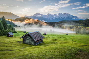 Sticker - Beautiful view of a wooden hut in the field and the mountains in the background