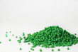 Green granules of polypropylene or polyamide on a white background. Plastics and polymers industry. Copy space.