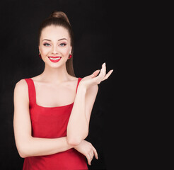 Wall Mural - Happy smiling woman with empty open hand on black background