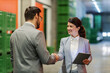 Making a deal in the warehouse. A man and a woman in a business suit shake hands and conclude a deal for the storage business. A businesswoman and a businessman at work successfully make a deal