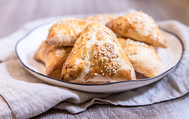 Wall Mural - Puff pastry buns with pumpkin sprinkled with sesame seeds. Homemade autumn pastries.