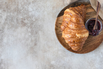 Wall Mural - Fresh crispy croissants with jam, concrete background. Homemade bakery for tasty breakfast. Top view. Copy space.