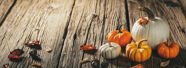 Wall Mural - mini pumpkins and leaves and acorns on rustic wooden harvest table - autumn decoration background