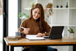 © David - Portrait of Young Asian woman hand freelancer is working her job on computer tablet in modern office. Doing accounting analysis report real estate investment data, Financial and tax systems concept.