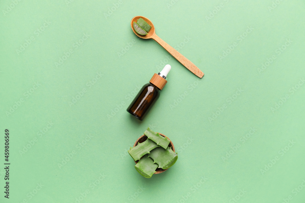 Cosmetic oil with aloe on color background