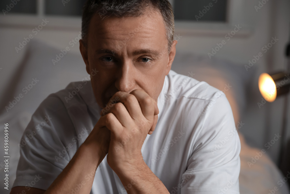 Depressed mature man in bedroom