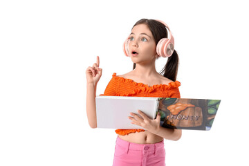 Canvas Print - Little girl with headphones and book pointing at something on white background