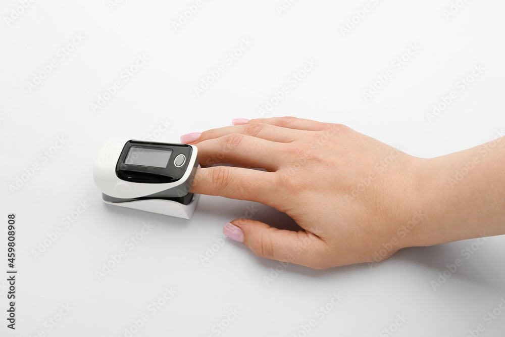 Woman with pulse oximeter on white background