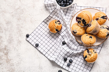 Wall Mural - Composition with tasty blueberry muffins on light background