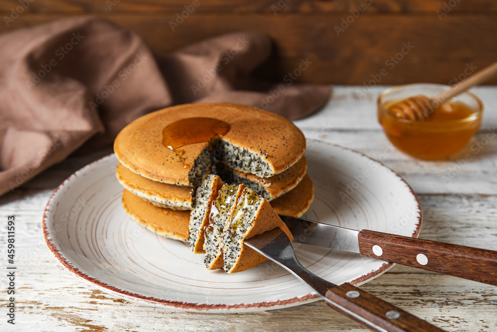 Plate of tasty pancakes with honey on table