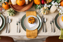Autumn Table Setting With Fresh Pumpkins And Flowers In Room