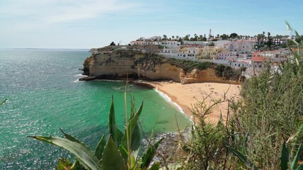 Wall Mural - Beautiful view of the Portuguese Carvoeiro beach in summer with clear sea and sunbathing tourists. Shooting in motion with a stabilizer.