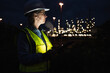 © Westend61 - Female engineer wearing hardhat and reflective clothing at factory during night