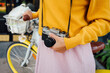 © Westend61 - Young woman with bicycle holding camera