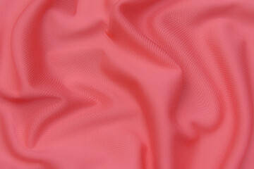 Wall Mural - Close-up texture of natural red or pink fabric or cloth in same color. Fabric texture of natural cotton, silk or wool, or linen textile material. Red and orange canvas background.