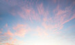 light pink cirrus clouds at blue sky background, sunset scenery with white shine