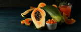 Fresh papaya and juice on wooden table, space for text