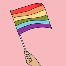 Hand Holding The Rainbow Pride Flag On Pink Background