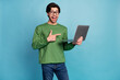 © deagreez - Photo of amazed shocked positive man point finger laptop wear glasses isolated on pastel blue color background