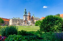 Wawel Castle In Krakow, In Summer With Sunny Sky And With Plants In Front Of The Photo