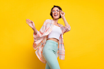 Wall Mural - Photo of positive happy cheerful young woman enjoy walk smile look empty space isolated on yellow color background