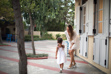 Wall Mural - Lovely little girl with mother at summer resort.