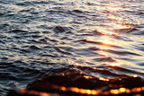 Fototapeta Morze - Sunset reflecting off of the ocean waves.
