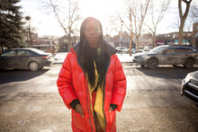 Portrait Beautiful Confident Young Woman In Red Coat On Sunny Street