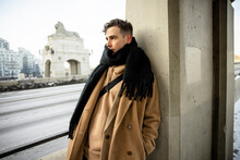 Handsome Young Man In Scarf And Wool Coat In Winter City