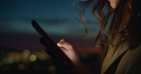 Close up on person use smartphone in sunset on street. Millennial generation z female scroll through news feed on app on her phone. Cinematic film look photo of pretty woman at sunset use phone