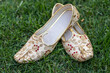 Pair of traditional Indian wedding male shoes. Indian wedding shoes. White, red, and gold men's wedding shoes. 