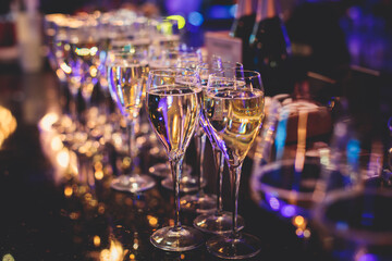 Line of alcohol setting on catering banquet table, bartender pouring beverages, row of different colored alcohol cocktails on a party, martini, vodka, and others on decorated banquet table event