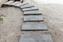 White Granite Walkway Slabs Patterned On The Sandy Beach