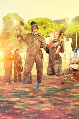 Canvas Print - Portrait of satisfied positive smiling man and woman paintball players delighted with their winning in match outdoors