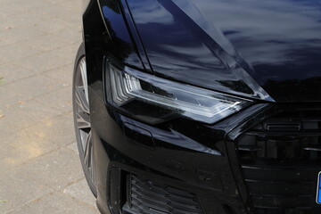 a modern car headlight with daytime running lights on a black car