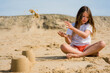 portrait of a pretty little girl making sand blocks on a sunny beach